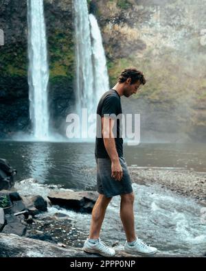 Homme debout devant la cascade de Wailua sur Kauai, Hawaï. Photo de haute qualité. Situé dans le parc national de Wailua River. Voyage à Hawaï Banque D'Images