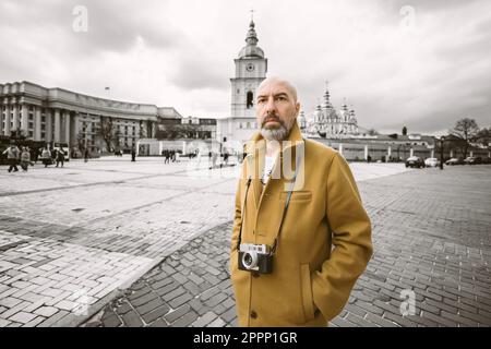 Beau photographe de barbe fait des photos sur film rétro appareil photo dans la ville de Kiev, Ukraine Banque D'Images