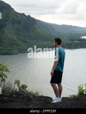 Homme regardant la randonnée Crouching Lion à Oahu, Hawaï. Photo de haute qualité. Belle vue sur la côte est d'Oahu. Banque D'Images