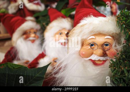 Une série de Santas décoratifs dans une rangée en période de Noël. Banque D'Images