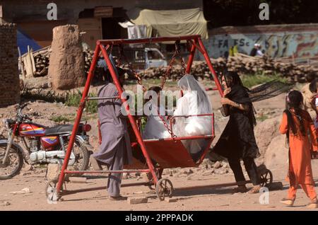 Peshawar, Khyber Pakhtunkhwa, Pakistan. 23rd avril 2023. Les enfants apprécient les balançoires à cheval pendant les célébrations d'Eid al-Fitr à Peshawar. Les musulmans du monde entier célèbrent Eid al-Fitr, le festival de trois jours marquant la fin du Saint mois de jeûne musulman du Ramadan. L'EID al-Fitr est l'une des deux grandes vacances de l'Islam. (Credit image: © Hussain Ali/Pacific Press via ZUMA Press Wire) USAGE ÉDITORIAL SEULEMENT! Non destiné À un usage commercial ! Banque D'Images