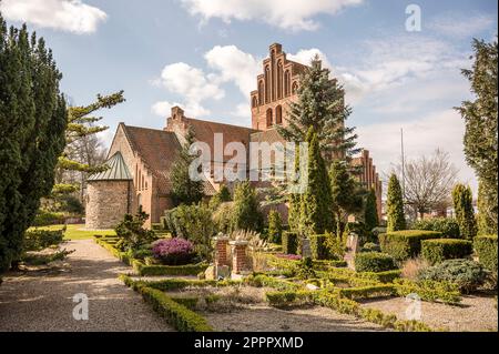 Une église en brique danoise et un cimetière dans l'après-midi soleil, Sæby, Zélande, Danemark, 6 avril, 2023 Banque D'Images