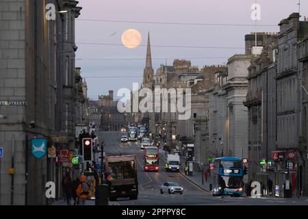 En regardant vers l'ouest le long de Union Street dans le centre-ville d'Aberdeen, alors que la pleine lune se met derrière le Gilcomston Church Spire tôt le matin d'avril Banque D'Images