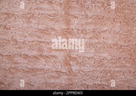 couverture beige doré ou brun clair en fausse fourrure à la texture déchiquetée comme arrière-plan. Fausse fourrure molletonnée. Banque D'Images