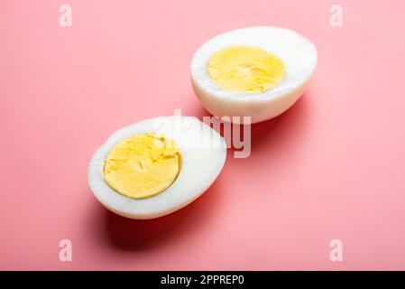 Œuf de poulet cuit en tranches sur fond rose. Banque D'Images