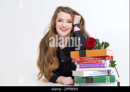 Médecin dentiste assis à la table et lisant des livres professionnels dans le cabinet blanc. Photo de haute qualité Ukraine Vinnitsa 2023 Banque D'Images