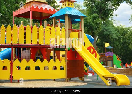 Nouvelle maison de jeu de château colorée avec toboggan sur l'aire de jeux pour enfants Banque D'Images