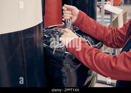 Une femme dans un magasin achète une grande poire noire pour la boxe et les arts martiaux Banque D'Images