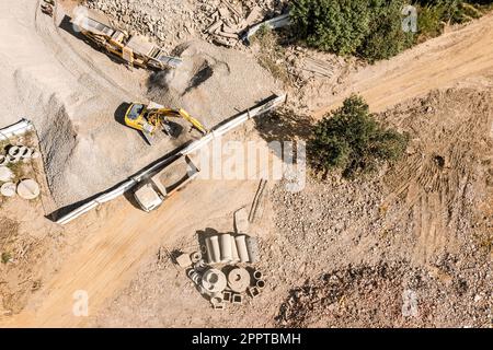 pelle hydraulique chargeant la pierre d'écrasement dans un camion à benne basculante. vue aérienne du chantier. Banque D'Images