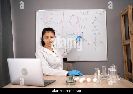 E-learning. Professeur de collège enseignant la chimie sur le Web, menant des cours en ligne à partir de la maison. Professeur du millénaire expliquant les formules chimiques Banque D'Images