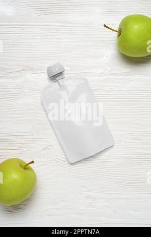 Sac en plastique blanc vide pour la nourriture de bébé, purée de fruits sur table en bois. Modèle de maquette pour la conception. 3d illustration du rendu. Banque D'Images