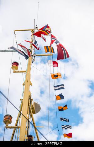 Drapeau de signalisation volant d'un mât de navire jaune Banque D'Images