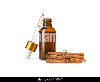 Bouteille d'huile essentielle naturelle et bâtonnets de cannelle secs sur fond blanc Banque D'Images