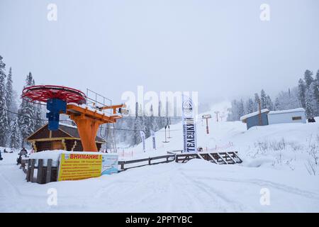 Iogach, Russie - 10 mars 2018 : station de ski d'hiver Teletsky Altai. Ascenseur à fermoir sur le mont et le fond de la forêt sous les chutes de neige. L'inscription Banque D'Images