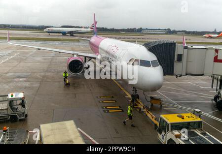 Wizz Air Airbus A320 au terminal sud de l'aéroport de Londres Gatwick, Angleterre, Royaume-Uni vu par une fenêtre de verre avec quelques réflexions Banque D'Images