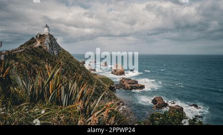 Vues épiques sur le phare de Nugget point et son arrière-plan rocheux, South Island, Nouvelle-Zélande Banque D'Images