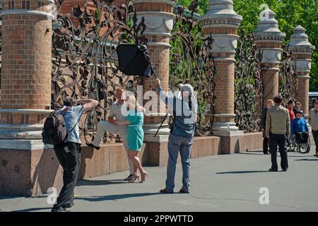 Rue 7 juin 2015 Petersbourg, Russie. Un photographe de rue avec un assistant prend des photos d'un couple amoureux. Photographe et touristes. Banque D'Images