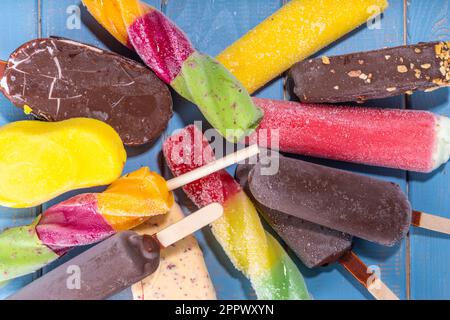 Divers popsicle de glace sur fond de bois turquoise, bonbons d'été, dessert, vacances et de vacances, ensemble de saveurs variées popsicle l Banque D'Images