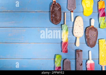 Divers popsicle de glace sur fond de bois turquoise, bonbons d'été, dessert, vacances et de vacances, ensemble de saveurs variées popsicle l Banque D'Images