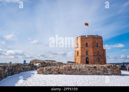 Drapeau lituanien agitant sur une tour du château de Gediminas contre le ciel bleu. Centre-ville et belle vue sur la rivière en hiver. Vilnius, Lituanie - 9 mars Banque D'Images