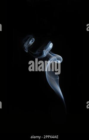 Un cliché vertical de fumée s'élève sur fond noir Banque D'Images