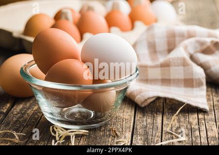 Œufs de poulet entiers dans un bol sur la table en bois. Banque D'Images