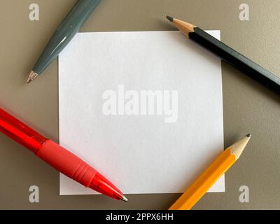 Petits morceaux carrés de papier pour notes et notes sur le bureau et stylos à bille avec crayons. Travail d'entreprise. Banque D'Images