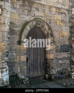Une ruine historique en pierre datant de 12th ans, à l'origine un hôpital. Une porte en bois est située dans une arcades de la pierre à émietter. Banque D'Images