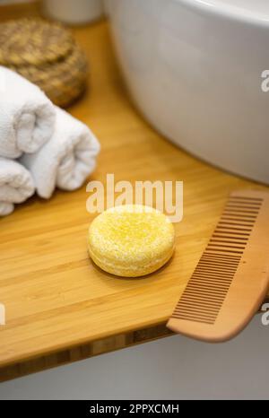 Barre de shampooing solide durable et accessoires de salle de bains posés sur une table en bambou. Sans plastique, sans déchets, ingrédients à faible teneur en eau. Cheveux écologiques Banque D'Images