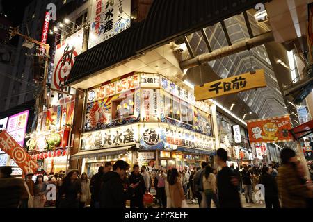 Une rue animée dans le célèbre quartier de Dotonbori à Osaka, au Japon, avec une variété de restaurants, de boutiques et d'activités animées Banque D'Images