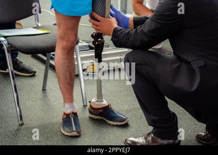 Physiothérapeute aidant le jeune homme avec la jambe prothétique Banque D'Images