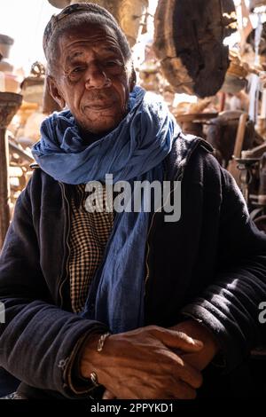 Portrait d'un vieux berbère vêtu de vêtements typiques de son groupe ethnique à la porte de son magasin. Banque D'Images