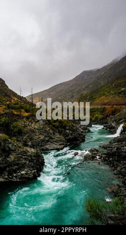 Eau turquoise d'une rivière glaciaire débordant au niveau des coutures après la pluie, South Island, Nouvelle-Zélande Banque D'Images