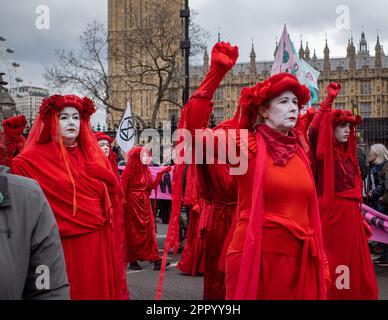 Les activistes du spectacle 'Brigade de la rébellion Rouge' défilent lentement devant Westminster dans le cadre de 'The Big One', fin de semaine de protestation de la rébellion d'extinction le 2023 avril. Banque D'Images