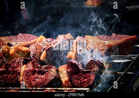 spiedini di carne sfrigolano sulla brace fumante, emanando un arome delizioso. Il calore del fuoco li rende succulenti e teneri Banque D'Images