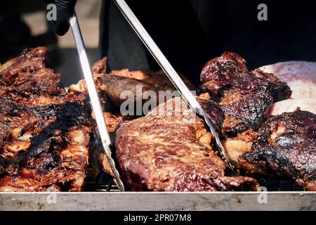 spiedini di carne sfrigolano sulla brace fumante, emanando un arome delizioso. Il calore del fuoco li rende succulenti e teneri Banque D'Images