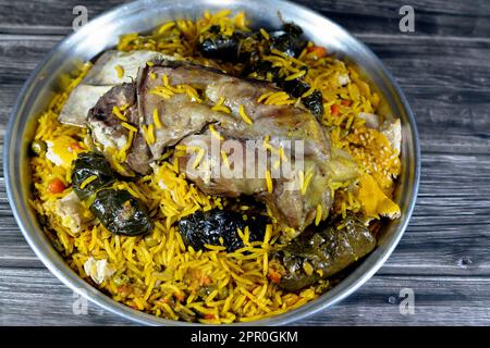 Une jarret d'agneau bien cuit avec du riz Basmati jaune et des légumes mélangés et des feuilles de raisin farcies mahshi Mahshy avec du riz blanc cuit rôti dans la ov Banque D'Images