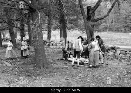 Les acteurs révolutionnaires de guerre vêtus de vêtements d'époque réadoptant les Parkers Revenge prendre soin d'un enfant malade dans le parc national historique de Minuteman sur les Patriots Banque D'Images