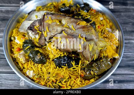 Une jarret d'agneau bien cuit avec du riz Basmati jaune et des légumes mélangés et des feuilles de raisin farcies mahshi Mahshy avec du riz blanc cuit rôti dans la ov Banque D'Images