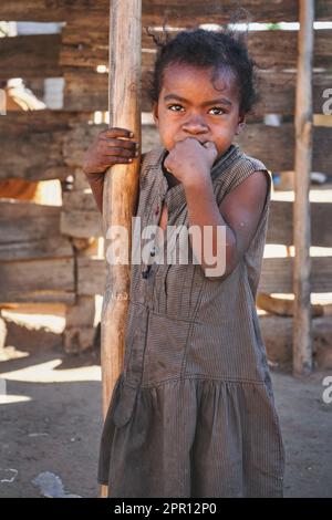 Ilakaka, Madagascar - 30 avril 2019: Inconnu pauvre enfant malgache debout dans la rue à côté de la cabane en bois, portant des vêtements donnés par les touristes Banque D'Images