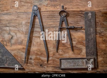 outils anciens de charpentier sur un bois, boussole antique à tracer et un carré pour bordure de bois, vieux matériel de dessin, horizontal Banque D'Images