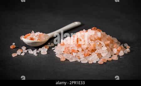 Une cuillère et un tas de cristaux de sel de l'himalaya rose. Sel rose ou sucre. Épices pour les recettes. Minéral. Banque D'Images