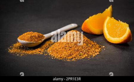 Épice d'orange séché. Cuillère et une pile d'orange grillée. Coupé frais en tranches. Épices pour les recettes. Banque D'Images