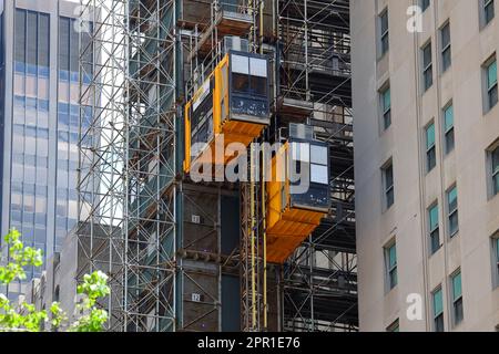 Un palan de construction Raxtar pour déplacer des personnes et des matériaux sur un chantier de construction de la ville de New York. Les élévateurs utilisent un système d'entraînement à crémaillère. Banque D'Images