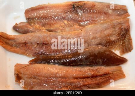 Morceaux de filets de hareng fumé chaud et de roe douce préparés avec de l'huile et du citron dans une assiette, concentration sélective de la cuisine de fruits de mer de l'harengs de poisson rea Banque D'Images