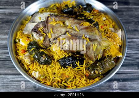 Une jarret d'agneau bien cuit avec du riz Basmati jaune et des légumes mélangés et des feuilles de raisin farcies mahshi Mahshy avec du riz blanc cuit rôti dans la ov Banque D'Images