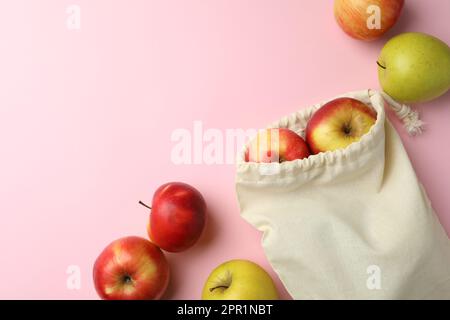 Sac écologique en coton et pommes sur fond rose, à plat. Espace pour le texte Banque D'Images
