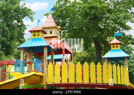 Nouvelle maison de jeu de château colorée avec toboggan sur l'aire de jeux pour enfants Banque D'Images