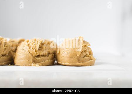 Pelles de pâte à biscuit à la vanille sur un plateau doublé de parchemin, pâte à biscuit à la vanille simple avec des flocons de sel sur le point d'être cuits Banque D'Images