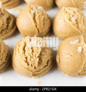 Pelles de pâte à biscuit à la vanille sur un plateau doublé de parchemin, pâte à biscuit à la vanille simple avec des flocons de sel sur le point d'être cuits Banque D'Images